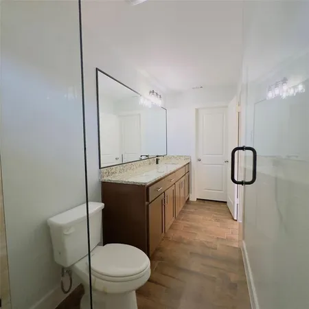 a bathroom with a granite countertop sink a toilet and a mirror