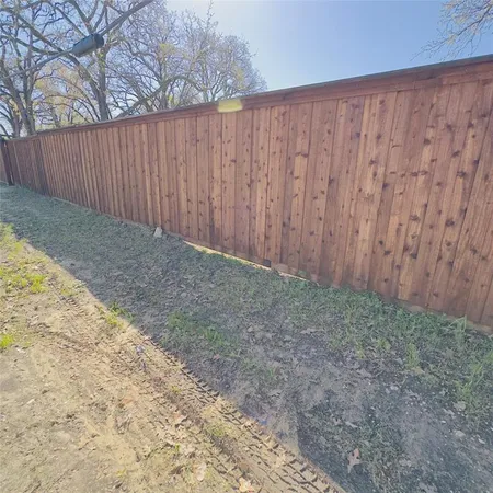a view of backyard with wooden fence
