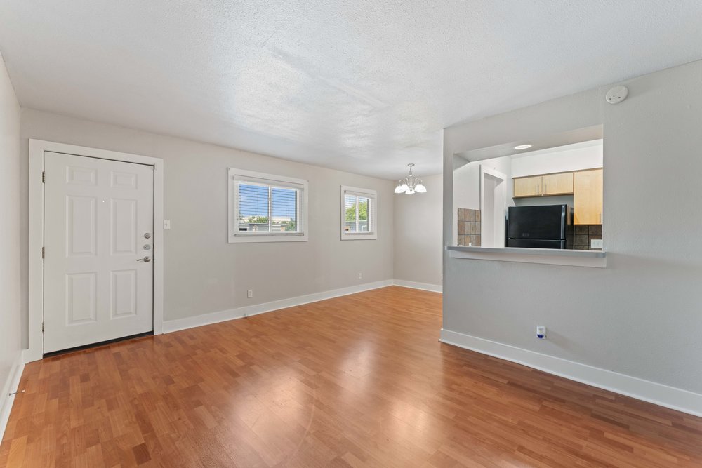 3815 Guadalupe Street, Unit 303 Austin, TX 78751 - Photo 7 of 21 Unfurnished living room featuring a chandelier, wood finished floors, and a textured ceiling