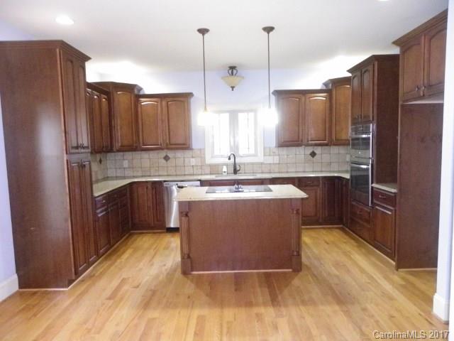 1808 Sam Smith Road Fort Mill, SC 29708 - Photo 4 of 20 a kitchen with stainless steel appliances granite countertop a refrigerator a sink dishwasher a stove with wooden floor