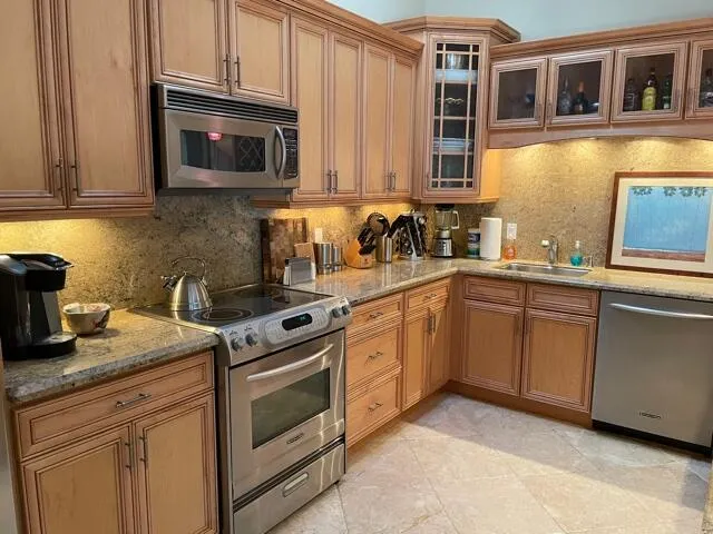 a kitchen with stainless steel appliances granite countertop a sink stove and microwave