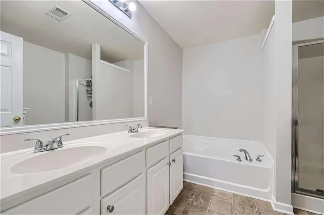 a bathroom with a granite countertop sink and a bathtub