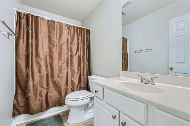 a bathroom with a sink a toilet and shower curtain