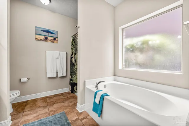 a bathroom with a bathtub and a painting on the wall