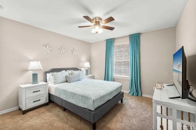 a bedroom with a bed and a flat tv screen on dresser