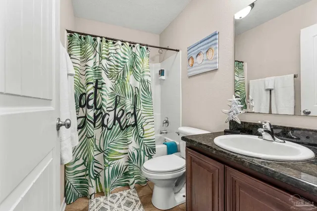 a bathroom with a granite countertop sink and a toilet