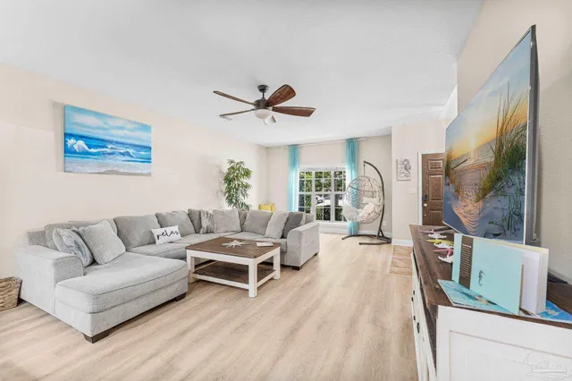 a living room with furniture a flat screen tv and a large window