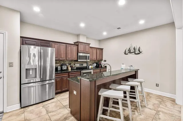 a kitchen with stainless steel appliances a refrigerator and a stove top oven