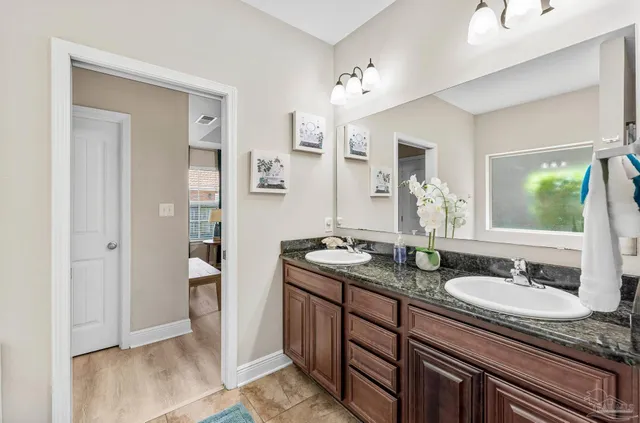 a bathroom with a granite countertop sink a mirror and a shower
