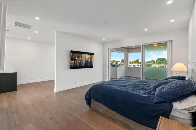 a large white kitchen with a large counter top a sink stainless steel appliances and cabinets