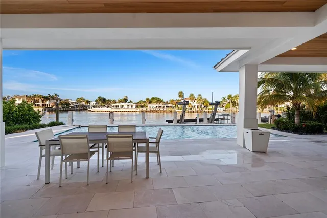 a view of a white house with couches and palm trees