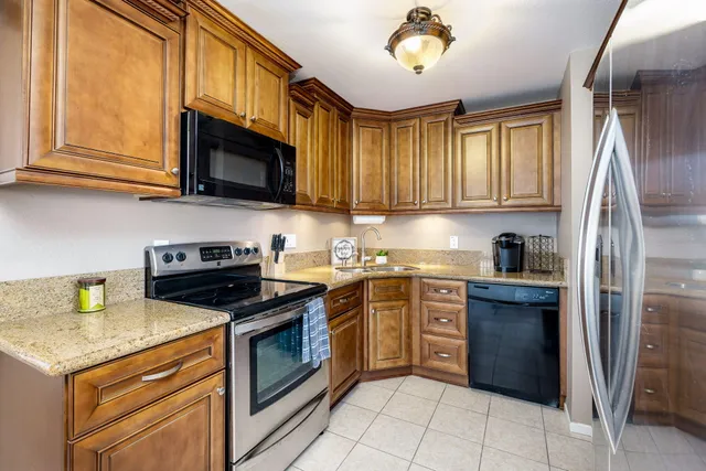 a kitchen with stainless steel appliances granite countertop a stove sink and cabinets