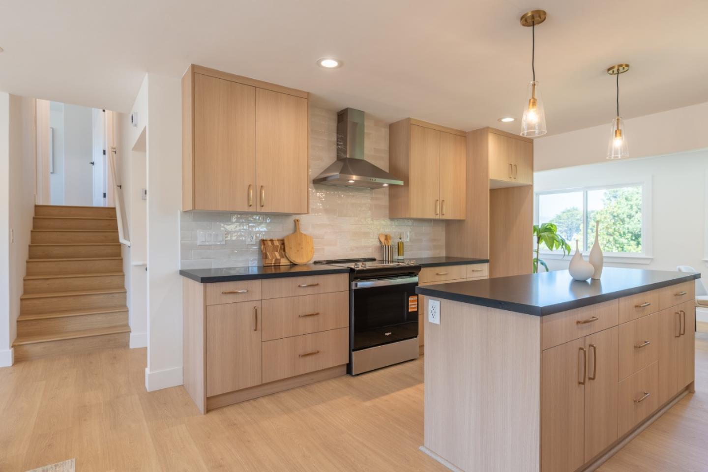 a kitchen with kitchen island granite countertop a sink a counter space appliances and cabinets
