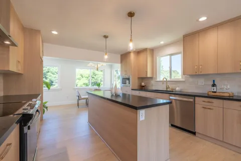 a kitchen with stainless steel appliances granite countertop sink stove and refrigerator
