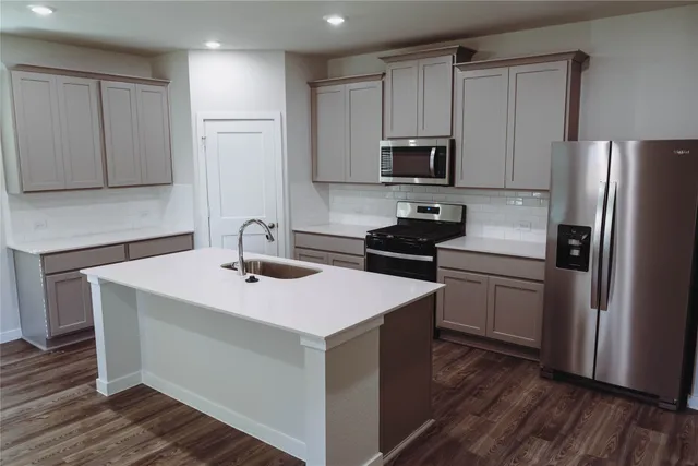 a kitchen with a sink stainless steel appliances and cabinets