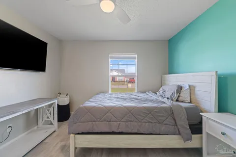 a bedroom with a bed and a flat screen tv