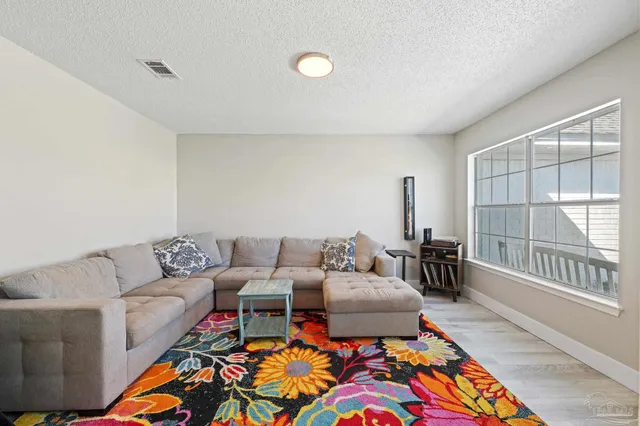 a living room with furniture a rug and a large window