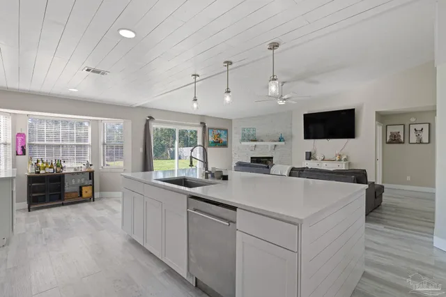 a large white kitchen with a large window and stainless steel appliances