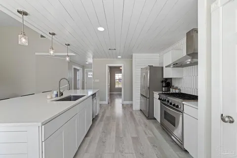 a kitchen with stainless steel appliances a sink stove and refrigerator