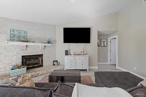 a living room with furniture a fireplace and a flat screen tv
