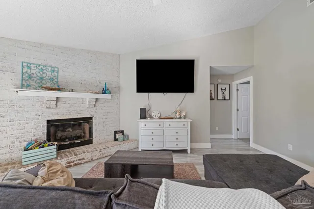 a living room with furniture a fireplace and a flat screen tv