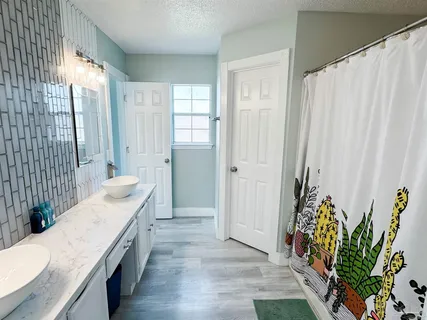 a spacious bathroom with a granite countertop tub a sink and a large mirror