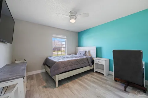 a spacious bedroom with a bed and a flat screen tv