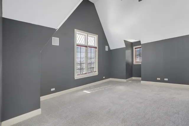 a spacious bedroom with a bed a table and potted plants