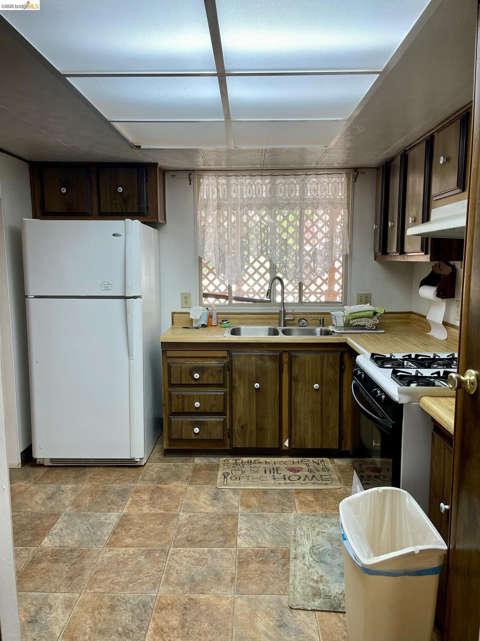 19361 Cherokee Road Tuolumne, CA 95379 - Photo 10 of 41 a kitchen with a stove a sink and a refrigerator