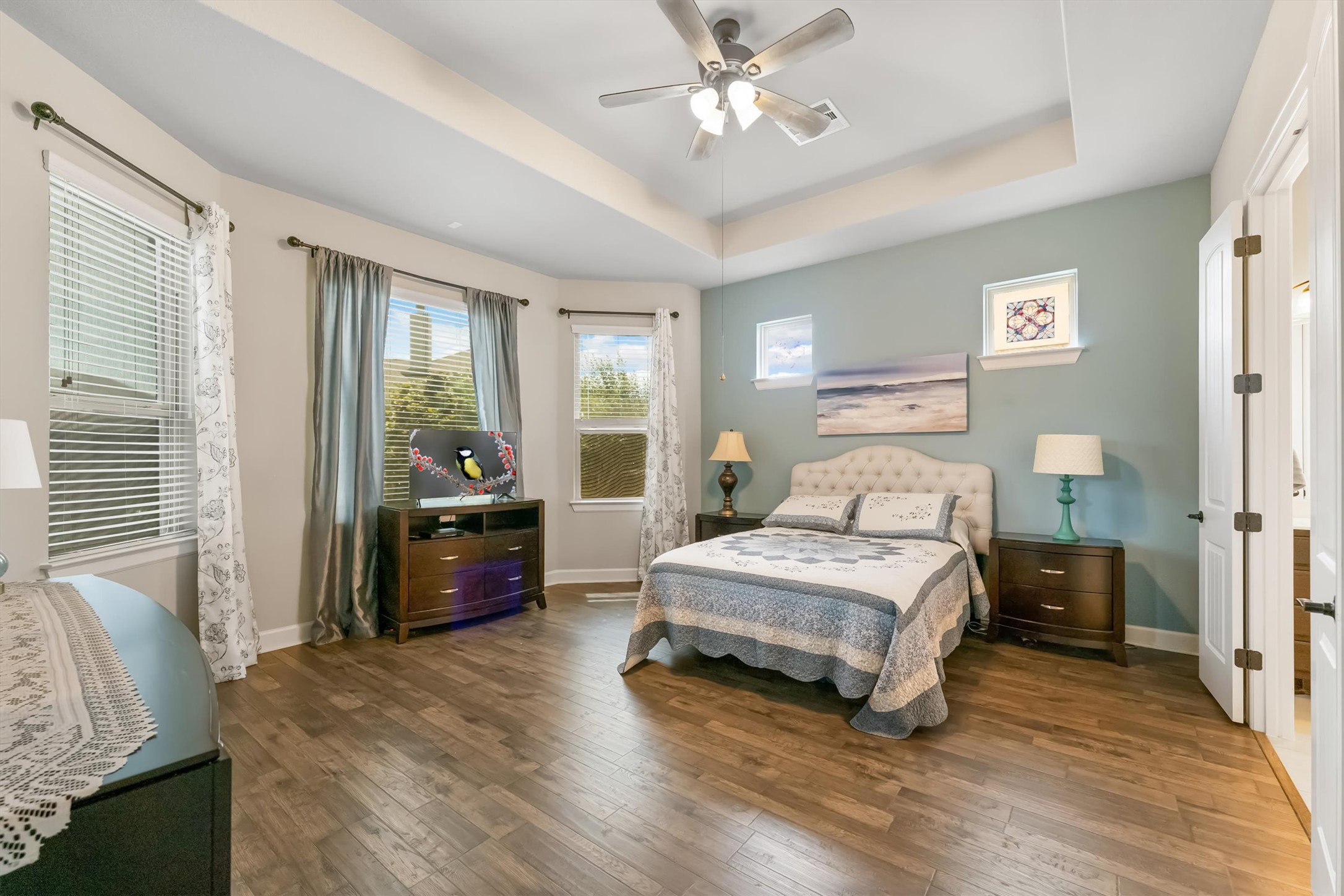 1004 Hezekiah Lane Leander, TX 78641 - Photo 15 of 36 Spacious room featuring wood-finish flooring, a tray ceiling with a ceiling fan, and multiple windows with blinds