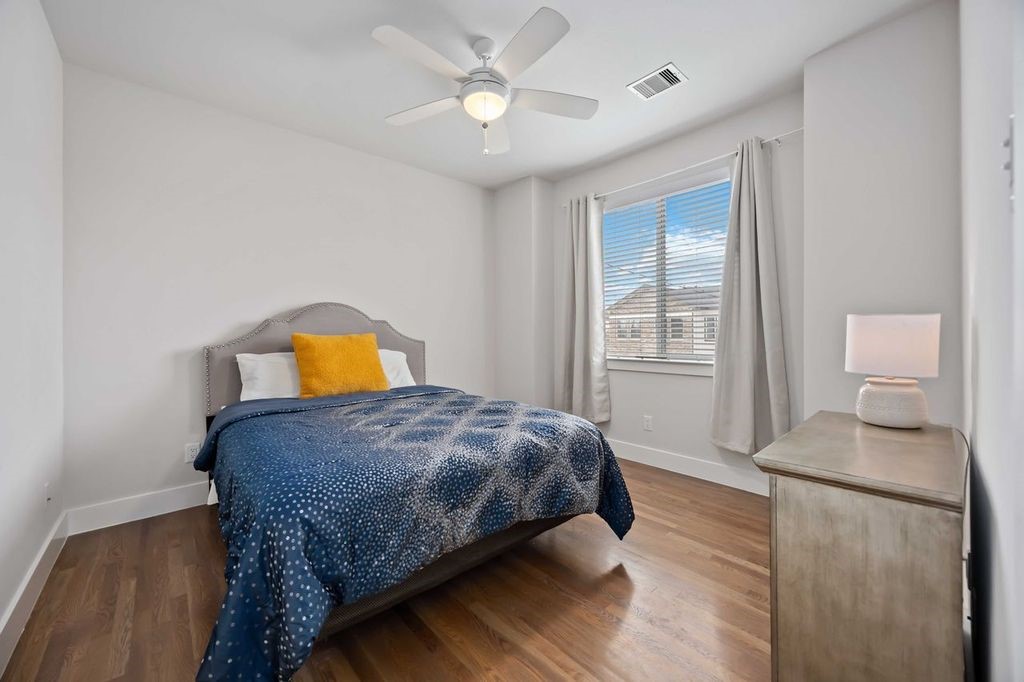 2314 Gagne Street Houston, TX 77020 - Photo 19 of 28 a bedroom with a bed and dresser with wooden floor