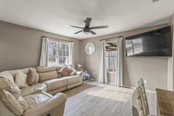 a living room with furniture ceiling fan and a window