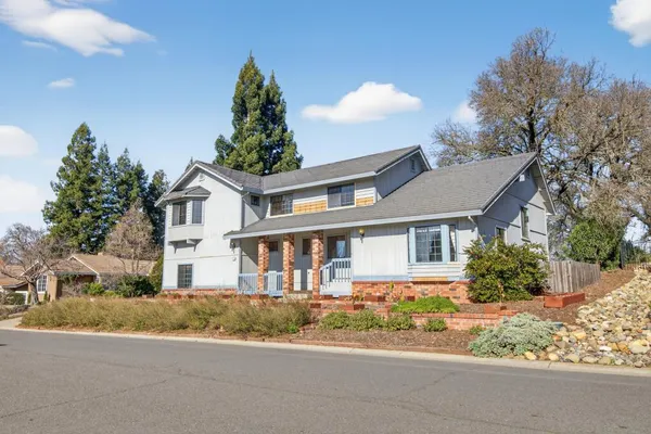 a front view of a house with a yard and potted plants