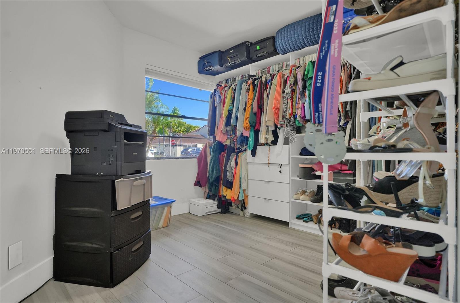 17032 Northwest 63rd Place Hialeah, FL 33015 - Photo 11 of 13 a view of walk in closet with clothes and shoes