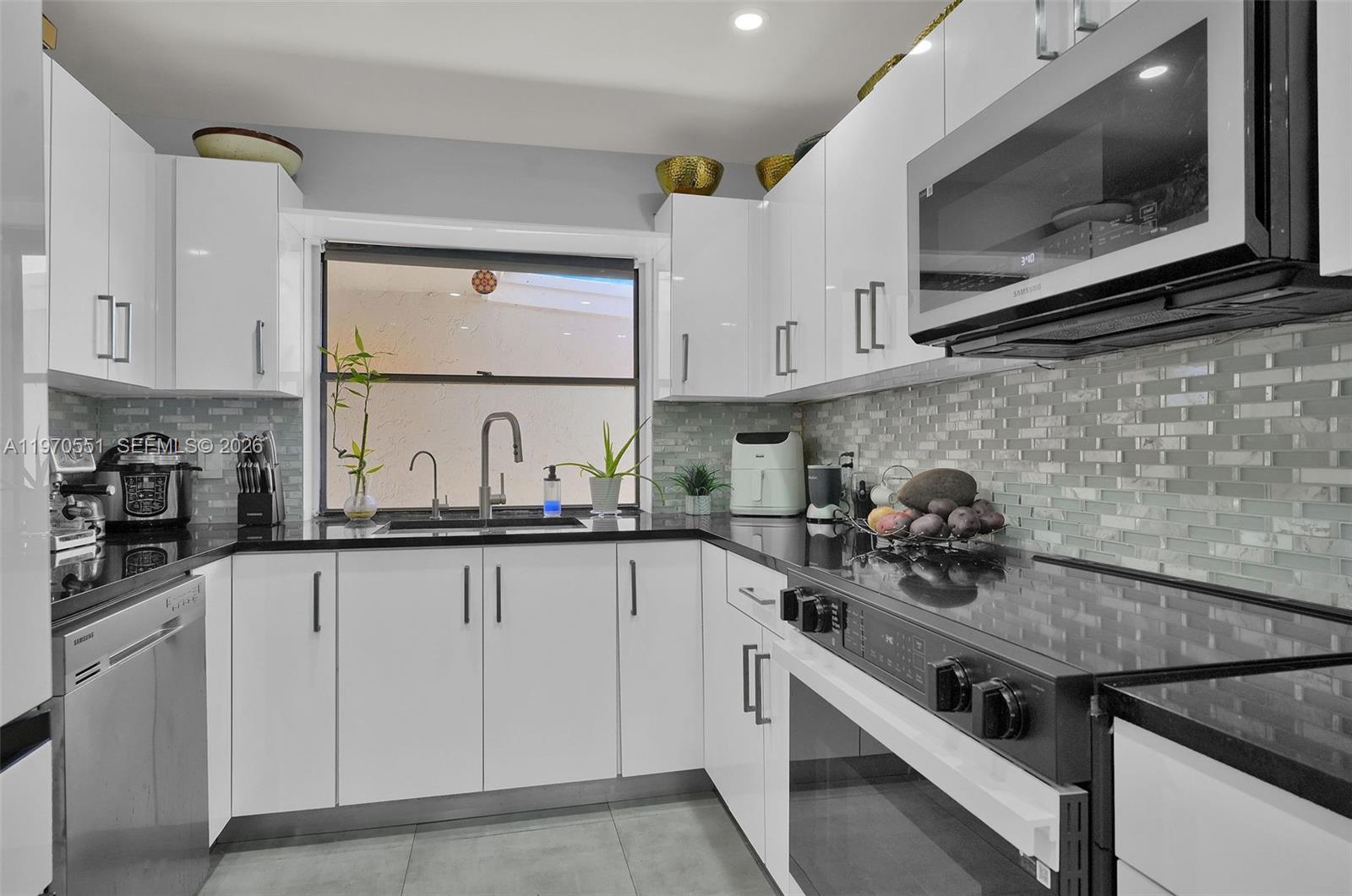 17032 Northwest 63rd Place Hialeah, FL 33015 - Photo 4 of 13 a kitchen with white cabinets and appliances