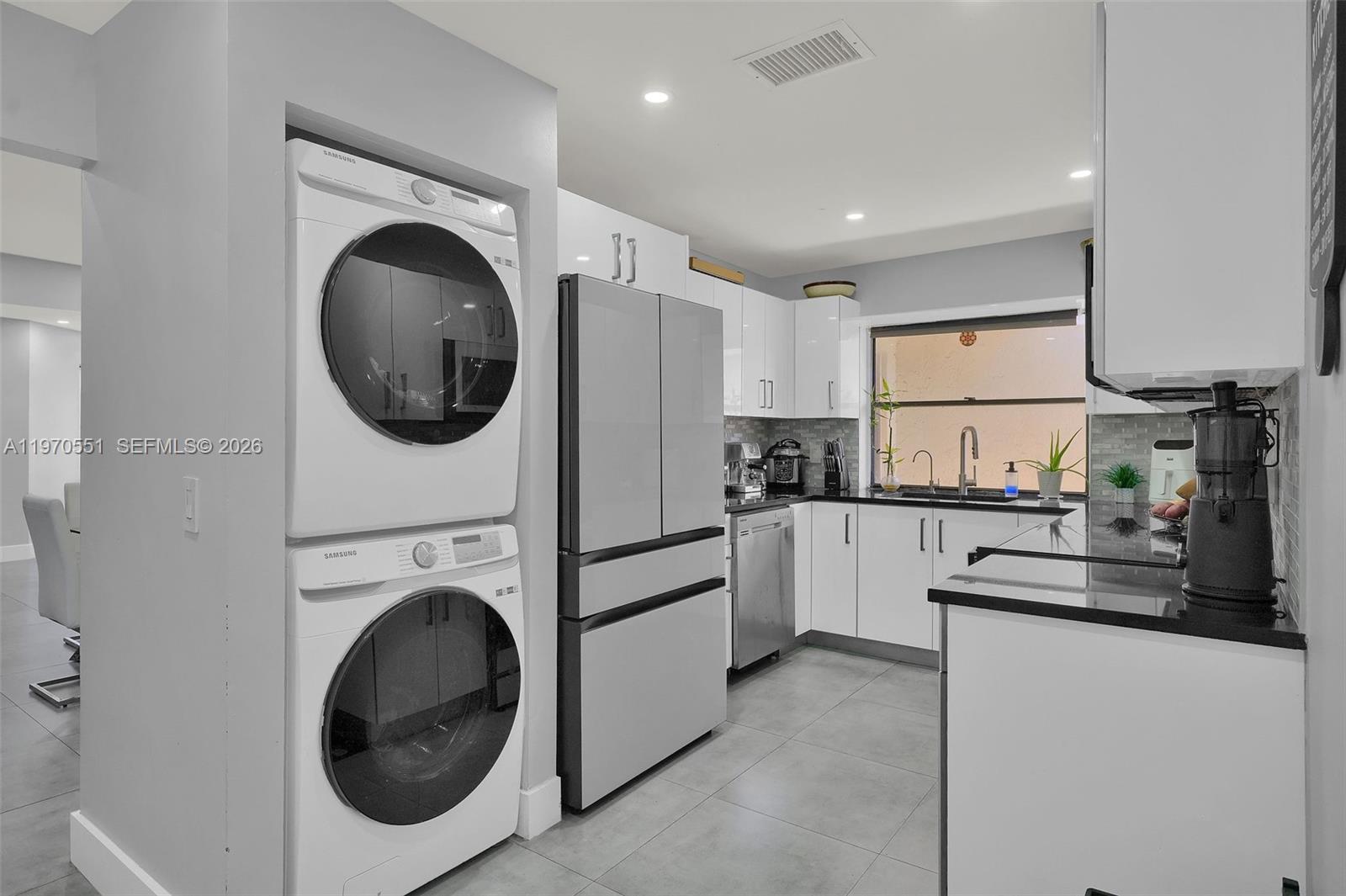 17032 Northwest 63rd Place Hialeah, FL 33015 - Photo 5 of 13 a kitchen with cabinets and washer dryer