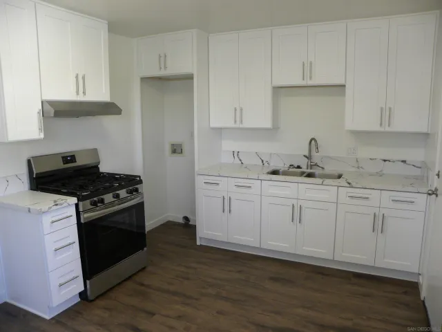 a kitchen with white cabinets and appliances