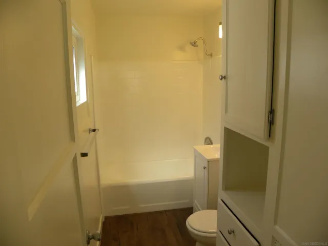 a bathroom with a granite countertop toilet and a shower