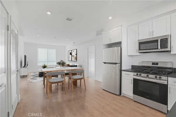 a kitchen with stainless steel appliances kitchen island a stove a sink a refrigerator and a microwave