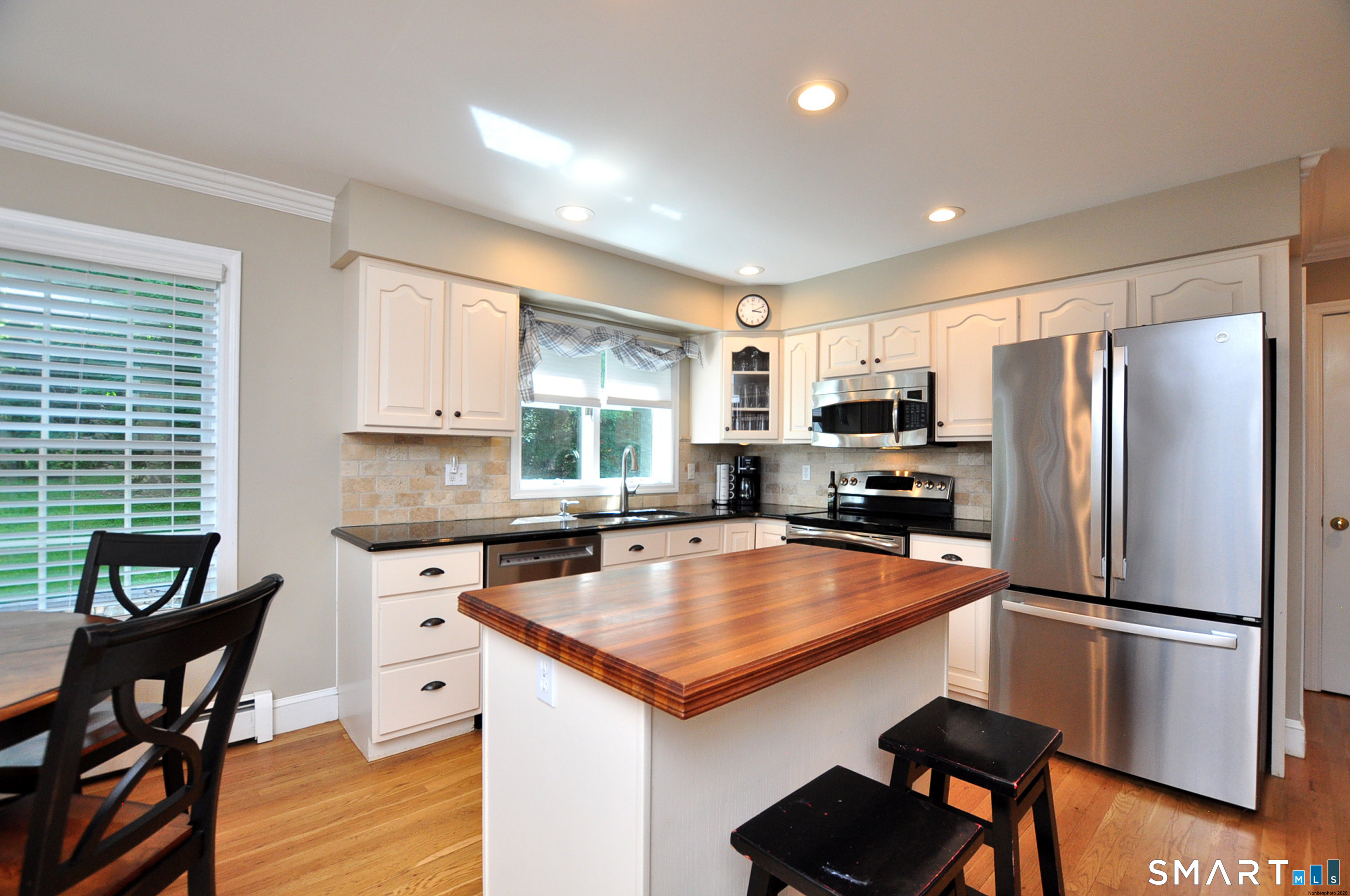 12 Revere Road Bridgewater, CT 06752 - Photo 16 of 40 a kitchen with stainless steel appliances granite countertop a refrigerator a stove a sink a dining table and chairs