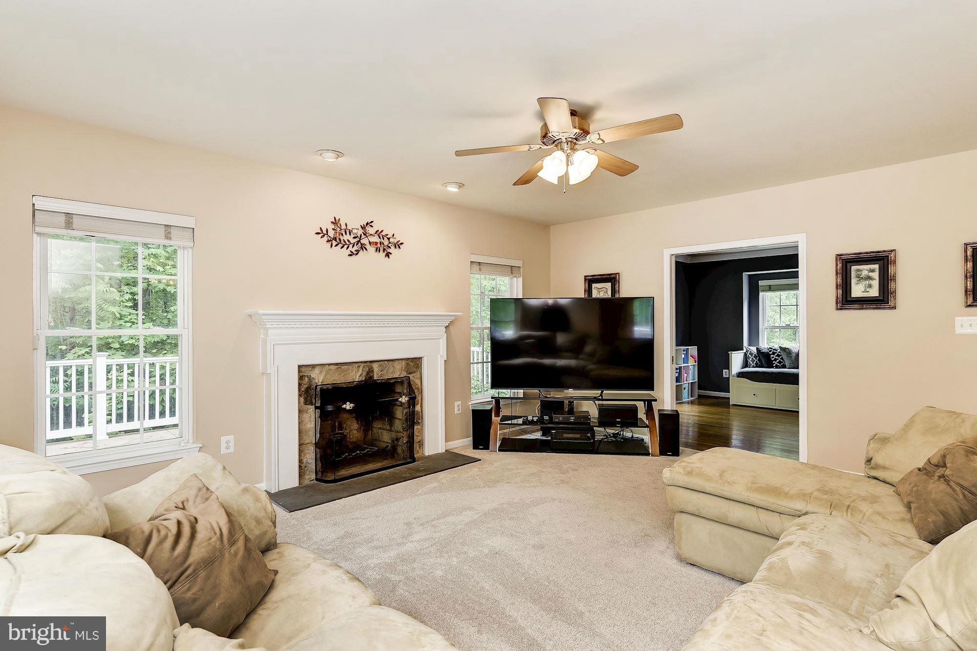 15530 Thompson Road Silver Spring, MD 20905 - Photo 11 of 30 a living room with furniture a fireplace and a flat screen tv