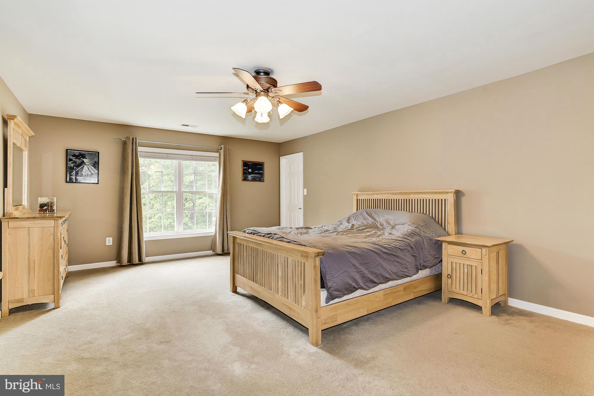 15530 Thompson Road Silver Spring, MD 20905 - Photo 15 of 30 a spacious bedroom with a bed and a chandelier