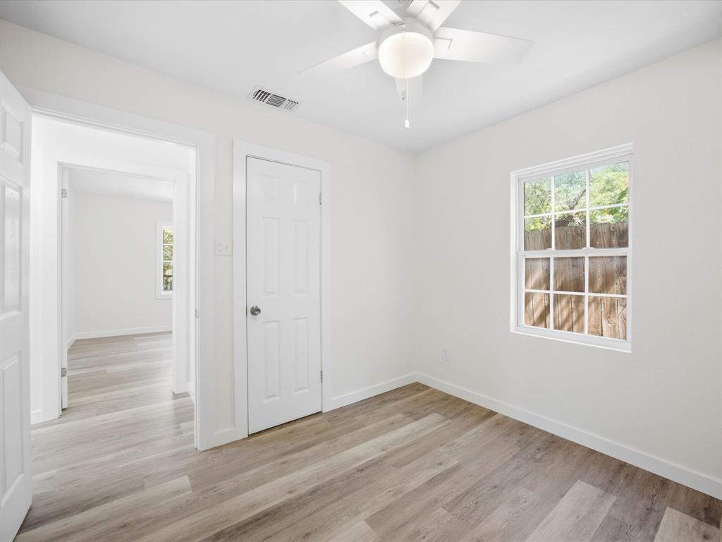 6933 Hatch Road Lake Worth, TX 76135 - Photo 17 of 28 Wood-finish flooring throughout, bright white walls, and a ceiling fan with integrated lighting