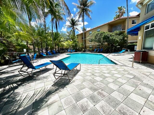 741 North Pine Island Road, Unit 303 Plantation, FL 33324 - Photo 32 of 32 a view of swimming pool with lounge chair and dinning table under an umbrella