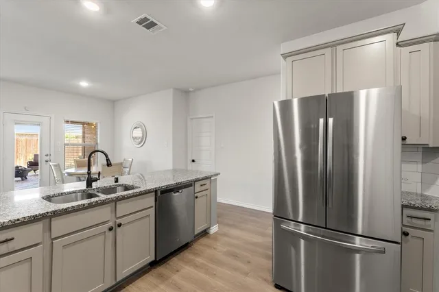 a modern kitchen with stainless steel appliances granite countertop a refrigerator and a sink