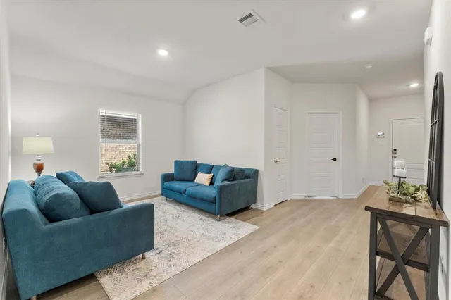 a living room with furniture and a wooden floor
