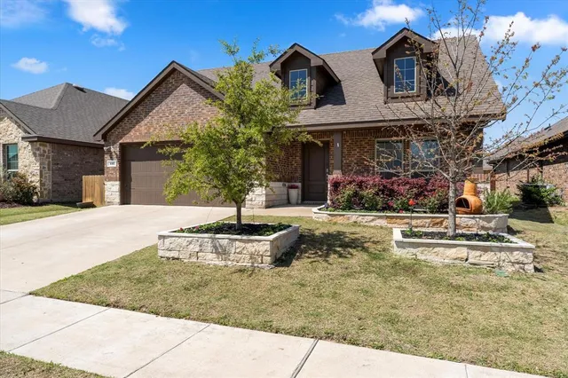 a view of a white house with a fountain and a yard