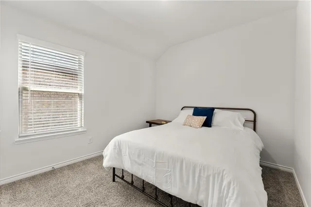a large bed sitting in a bedroom next to a window
