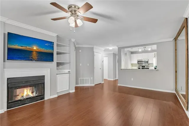a view of a kitchen a ceiling fan wooden floor and a kitchen