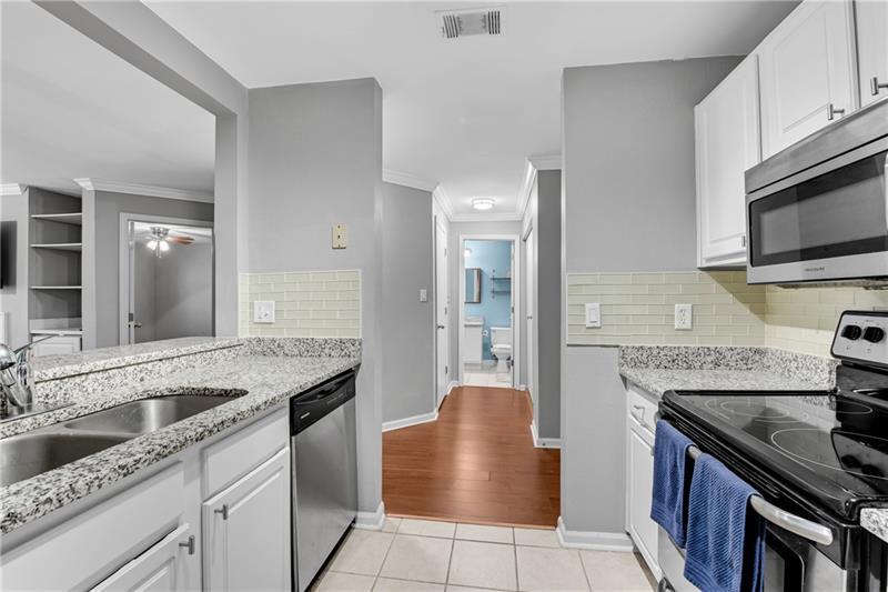 3655 Habersham Road Northeast, Unit 244B Atlanta, GA 30305 - Photo 11 of 34 a kitchen with granite countertop a sink and a stove